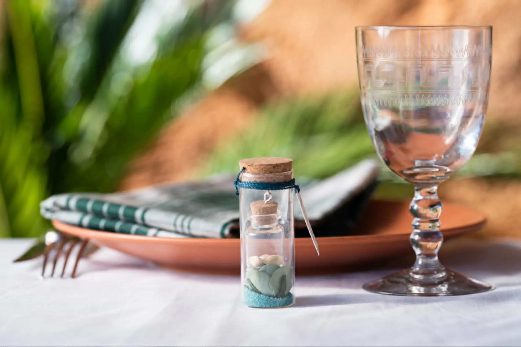 Une fiole de graines au sable bleu-vert, prête à offrir sur une table de réception