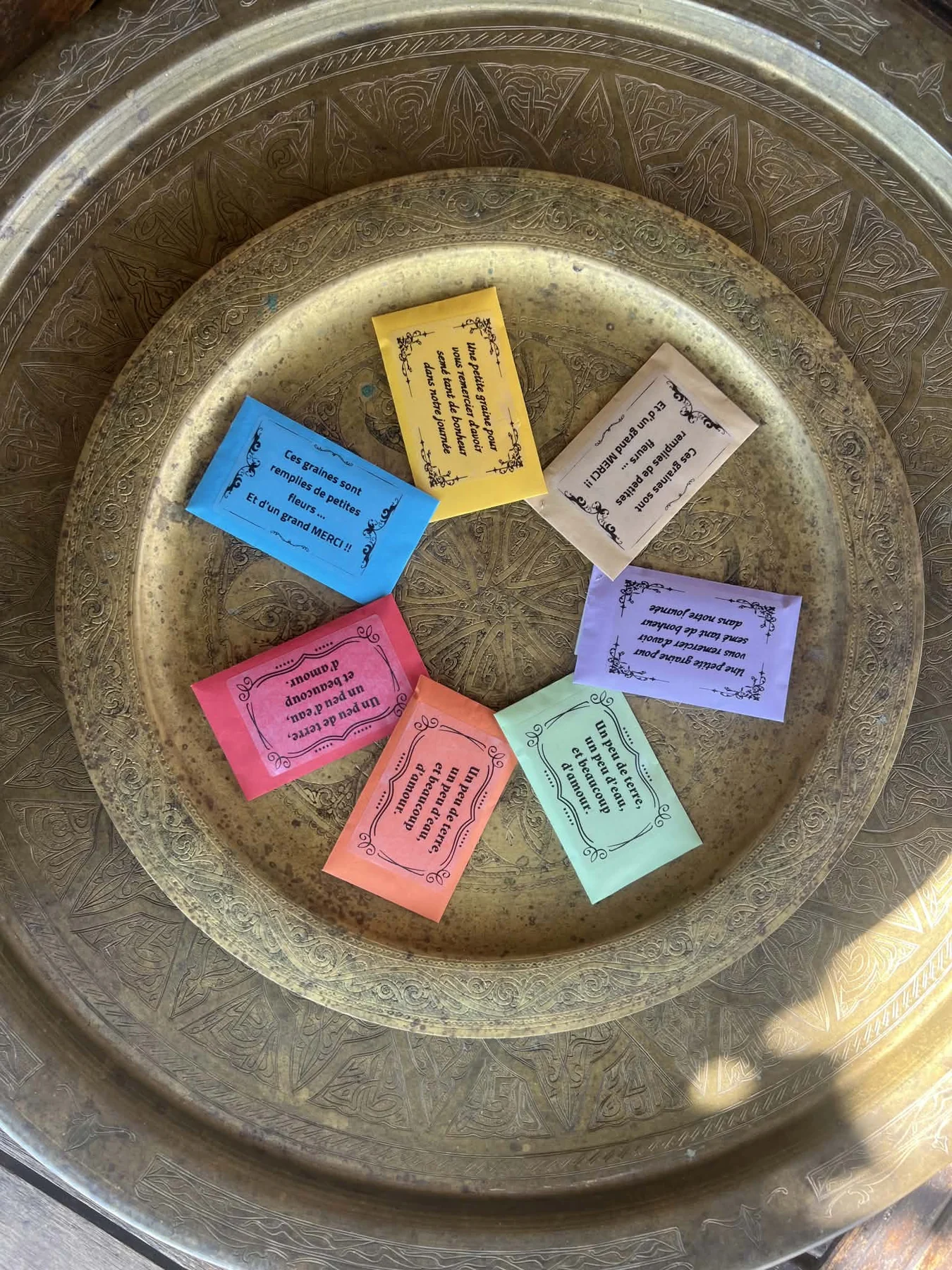 Des sachets de graines colorés avec des messages personnalisés, présentés sur un plateau